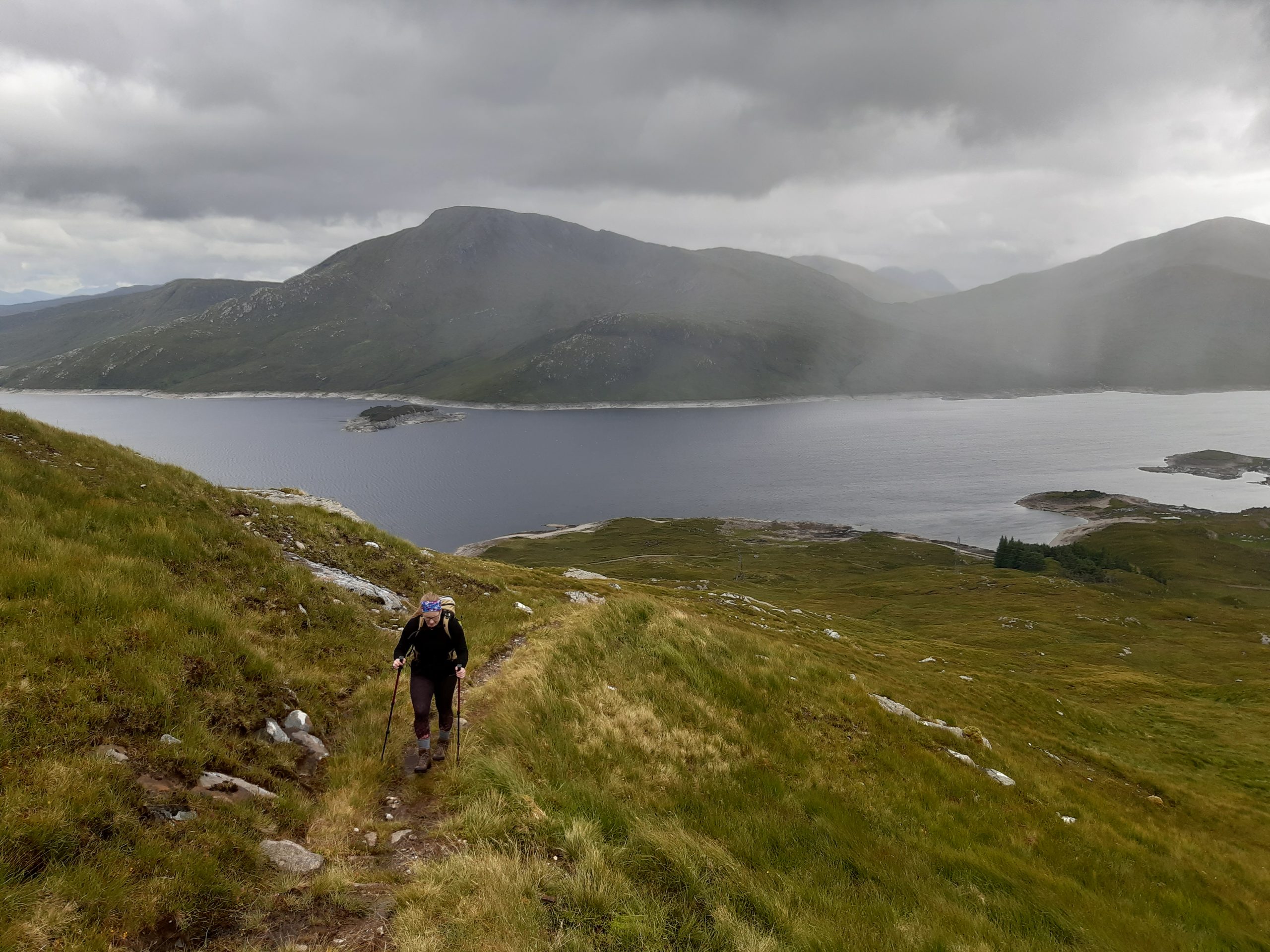 Walking up a hill with Loch Quoich on the background.