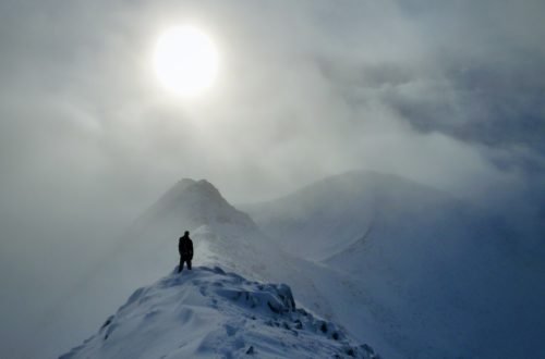 Winter walk on a snowy ridge in Scotland